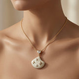 Constellation Ivoire Jewellery Set - necklace worn on mannequin décolletage showing pear crystal connector and ivory fan pendant at collarbone length