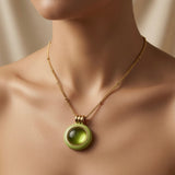 Pistache Cabochon Pendant Necklace - worn on model collarbone showing pendant at throat length, pistachio green and gold against skin