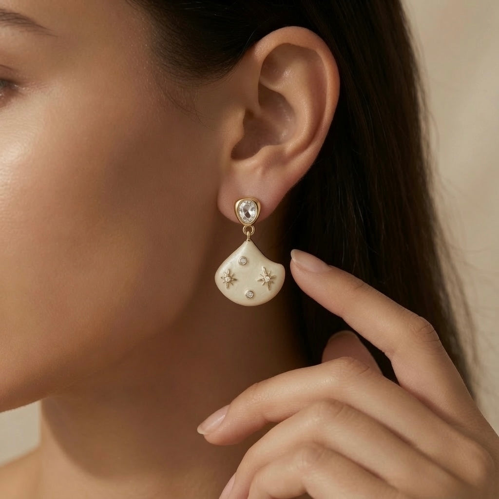 Constellation Ivoire Jewellery Set - earrings worn on model ear showing oval crystal stud at lobe and ivory constellation fan drop below jaw
