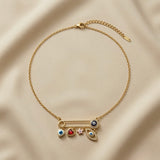 Amour Nazar Pin Charm Necklace - full flat lay on ivory silk showing complete gold cable chain with lobster clasp and curb extender, large gold safety pin centrepiece with navy pavé evil eye clasp and five sliding charms: evil eye heart, ruby heart, pink star and pavé marquise evil eye