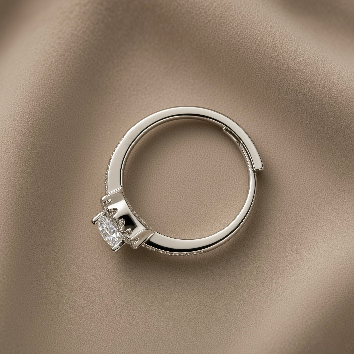 Éclat Wide Band Solitaire Adjustable Ring - side profile on taupe silk showing wide flat-topped mirror-polished band with open-back adjustable gap at base, micro-pavé crystal shoulder accents and round brilliant crystal zirconia solitaire in four-prong setting