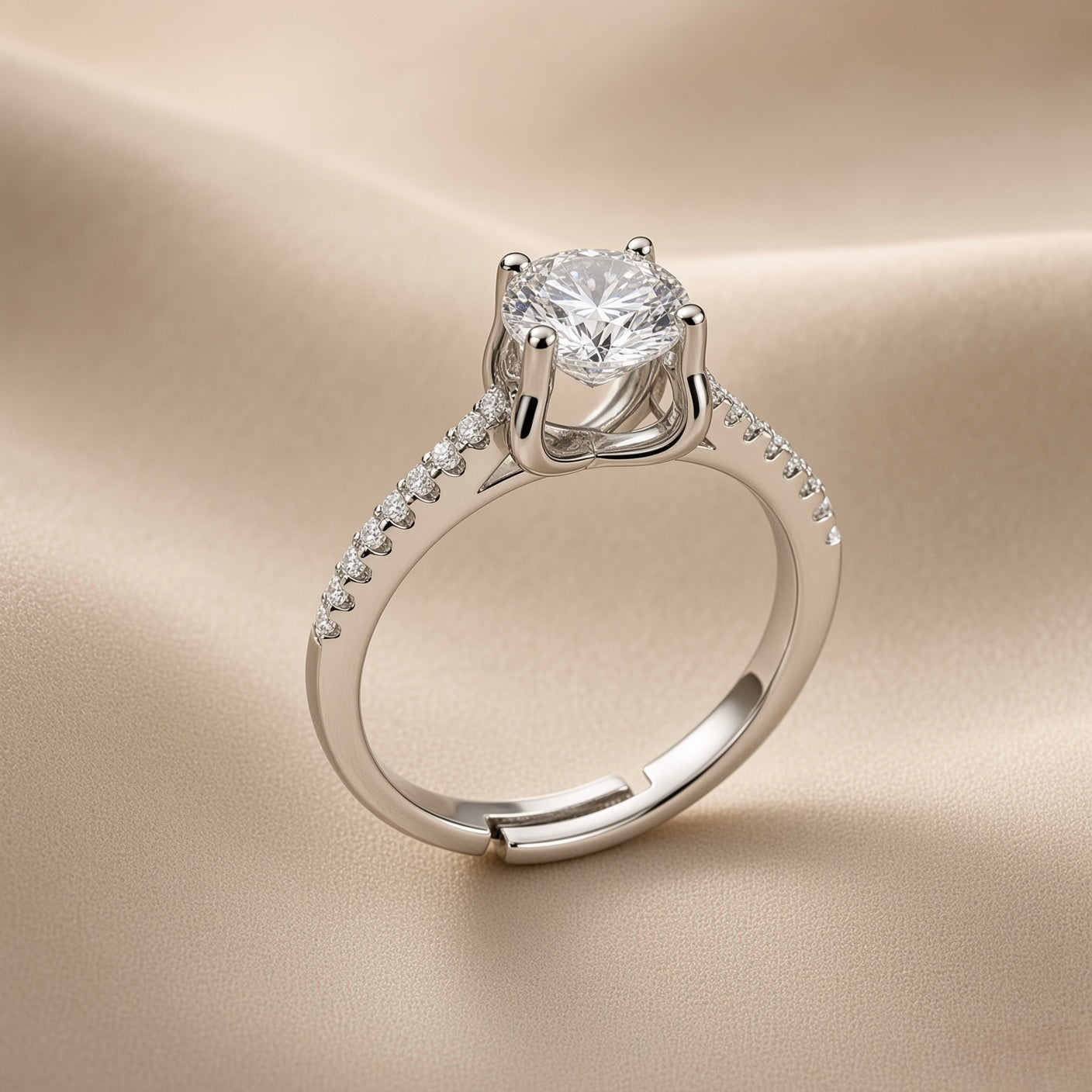 Lumière Solitaire Pavé Adjustable Ring - three-quarter view on champagne silk showing complete ring: round brilliant crystal zirconia solitaire in four-prong cathedral setting elevated above band, sculpted gallery beneath stone, pavé crystal zirconia accents along both shoulders on rhodium-plated silver-tone band with open-back adjustable mechanism at base
