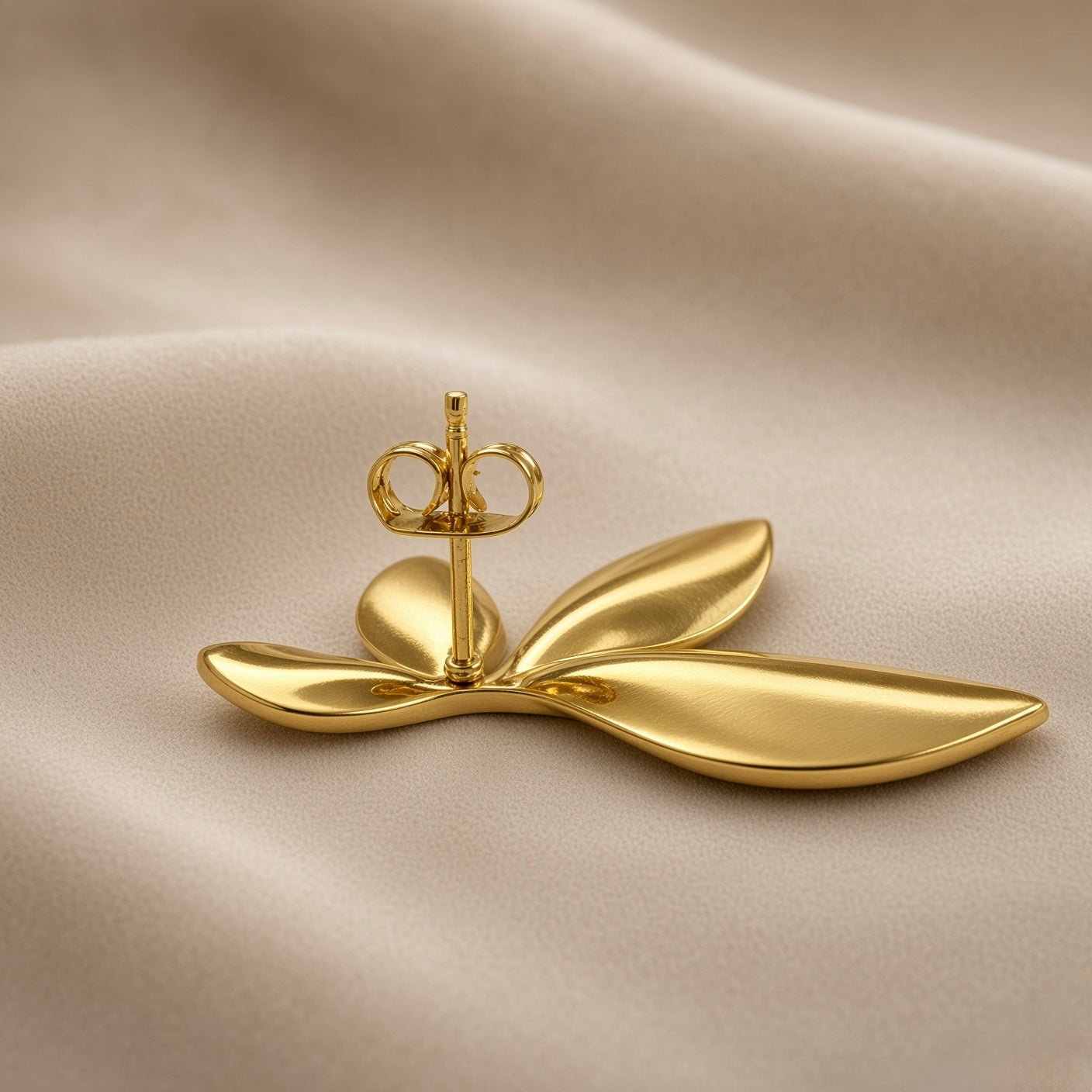 Feuilles d’Or Multi-Leaf Cluster Stud Earrings - single earring back view on champagne silk showing reverse of five-leaf cluster stud earring: domed gold disc base plate at centre with standard gold post and butterfly clutch back, smooth mirror-polished gold reverse surfaces of leaf forms visible