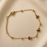 Rosette Bud Station Chain Bracelet - worn on model wrist showing bracelet in circular form: fine gold cable chain with gold ball stations and three rose bud charm stations with round rose-pink faceted crystals and dark green enamel marquise sepal elements distributed across front wrist arc, lobster clasp with extender chain visible at left