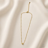 Étoile du Cœur Puffy Heart Satellite Chain Necklace - full length flat lay on champagne silk showing complete necklace laid straight: fine satellite chain with smooth gold ball stations, three-dimensional puffy heart pendant with star crystal centre at base, lobster clasp and extender chain at top