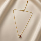 Toi et Moi Diamond Ruby Two-Stone Pendant Necklace - full length flat lay on champagne silk showing complete necklace from slightly different angle: fine oval-link gold cable chain with toi et moi pendant showing princess-cut white crystal zirconia and pear-cut deep ruby red crystal zirconia in shared gold setting, lobster clasp and curb-link extender chain at top