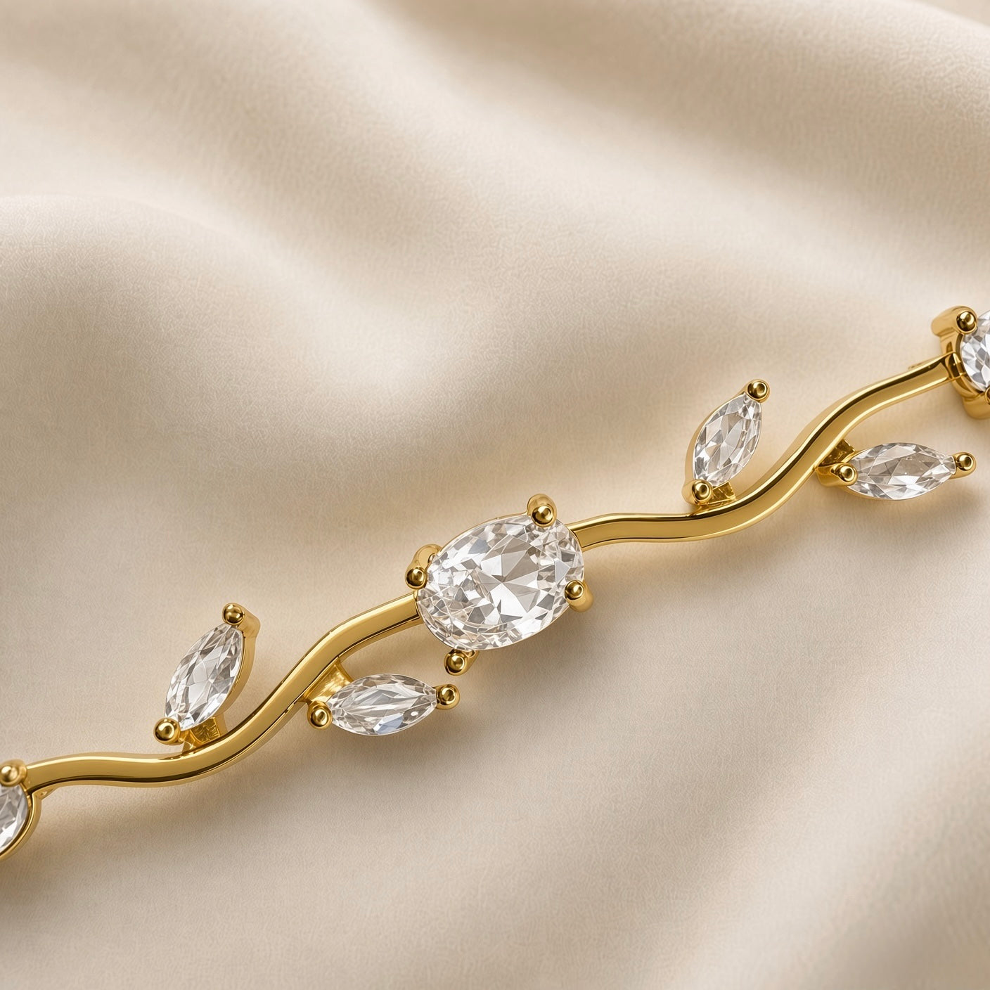 Diamant Vigne Wave Link Crystal Bracelet - macro close-up on champagne silk showing three links in detail: large oval brilliant-cut white crystal zirconia in four-prong ball-tip gold setting at centre showing diamond-like white brilliance and facet detail, paired marquise navette white crystal zirconia in two-prong point-tip settings on sinuous S-curve gold wave links, warm gold ball-tip prong detail clearly visible
