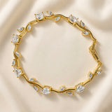 Diamant Vigne Wave Link Crystal Bracelet - circular flat lay on ivory silk showing complete bracelet in full circle: sinuous gold wave vine links with alternating large oval brilliant-cut white crystal zirconia in four-prong ball-tip settings and paired marquise white crystal zirconia in two-prong settings on wave curves, box clasp with safety tab visible at right