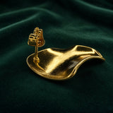 Gold Sculptural Wave Square Stud Earrings - back view on deep forest green velvet showing single earring reverse: straight gold post with butterfly friction clutch back, smooth warm gold back surface with three-dimensional wave form visible from behind, deep concave warping of square form clearly visible