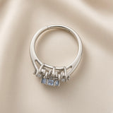 Sky Blue Crystal Snowflake Halo Ring - side profile on ivory satin showing ring band construction and second ring: split shank silver ring with three princess-cut pale blue crystal zirconia in bar claw settings flanked by small round white crystals, two parallel rails splitting at front and rejoining at back