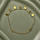 Gold Teardrop Charm Satellite Chain Anklet - full flat lay on sage green satin showing complete anklet from slightly closer angle: fine satellite chain with seven alternating teardrop charms showing solid gold teardrops and bezel-set nude cabochon teardrops in alternating composition, lobster clasp and curb-link extender chain at bottom right, gold ball stations along chain clearly visible