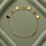 Gold Teardrop Charm Satellite Chain Anklet - full flat lay on sage green satin tray showing complete anklet in circular layout: fine gold satellite chain with evenly spaced gold ball stations carrying seven alternating teardrop charms along upper arc, solid mirror-polish gold flat teardrop charms alternating with open gold bezel nude cabochon teardrop charms, lobster clasp and curb-link extender chain at bottom right