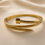 Top view of a polished gold-tone double band cuff bracelet with open design