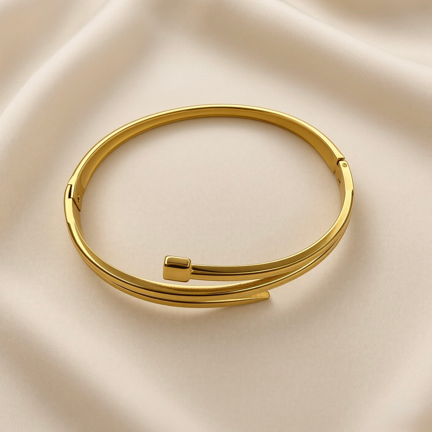 Gold-tone double band open cuff bracelet with polished bar detail on beige fabric