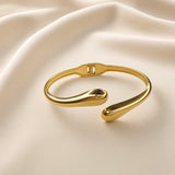 Minimalist gold-plated stainless steel open cuff bracelet worn on a wrist