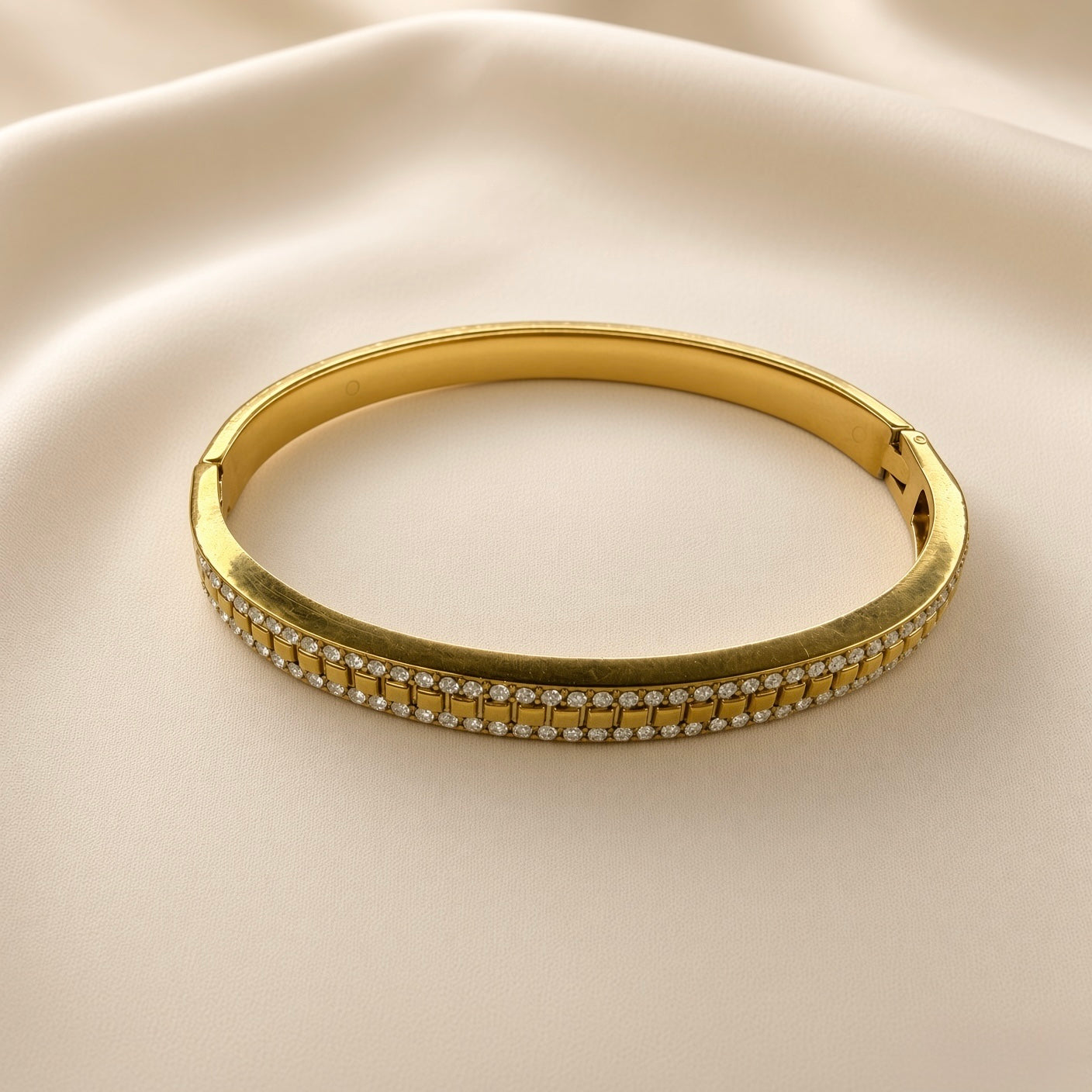 Gold-plated stainless steel bangle showing the structured clasp closure and polished inner band