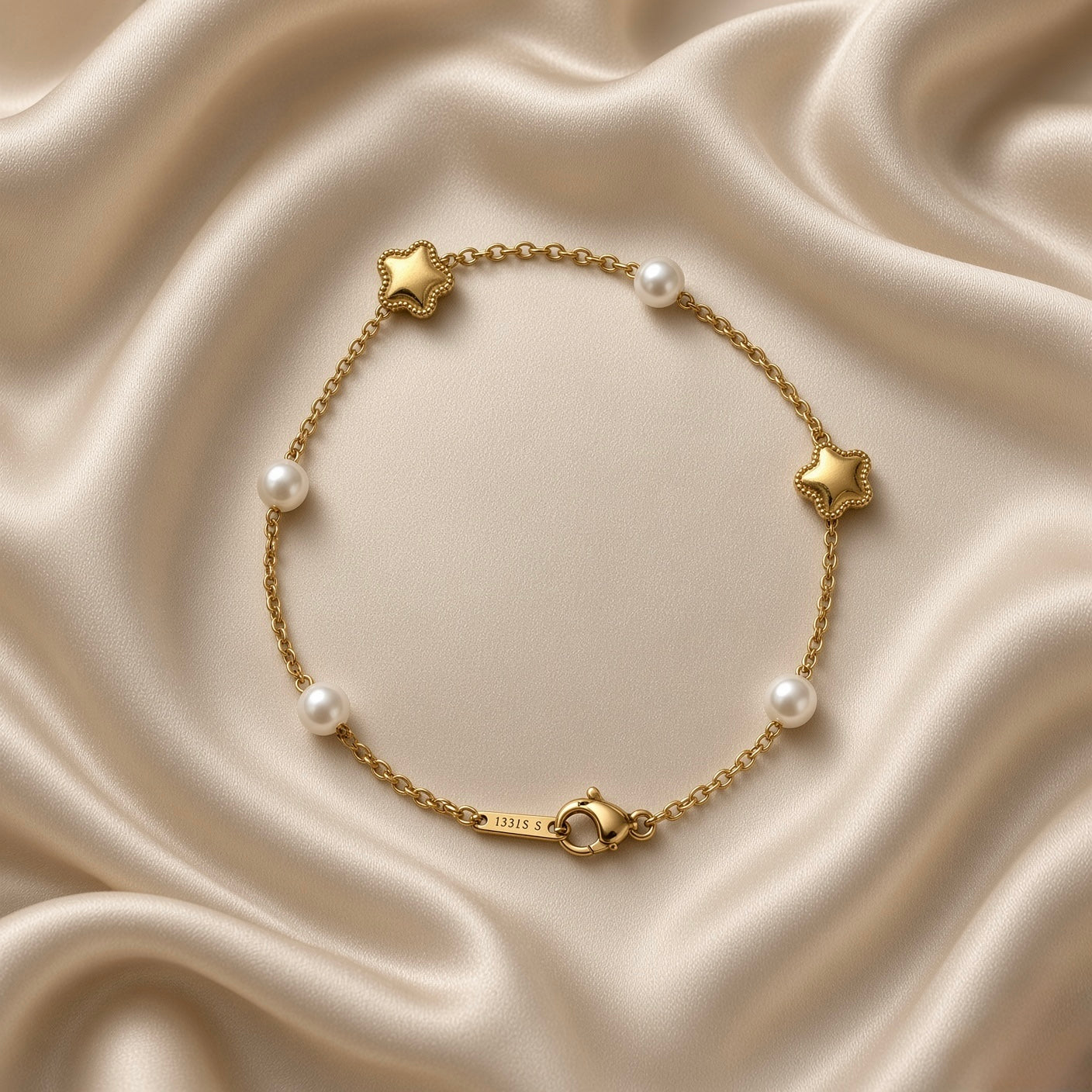 Gold Star and Pearl Station Bracelet Milgrain - macro detail on cream satin: puffy three-dimensional milgrain bead border gold star charm with mirror-polish domed surface and round white freshwater pearl station on fine gold cable chain, star milgrain border detail clearly visible