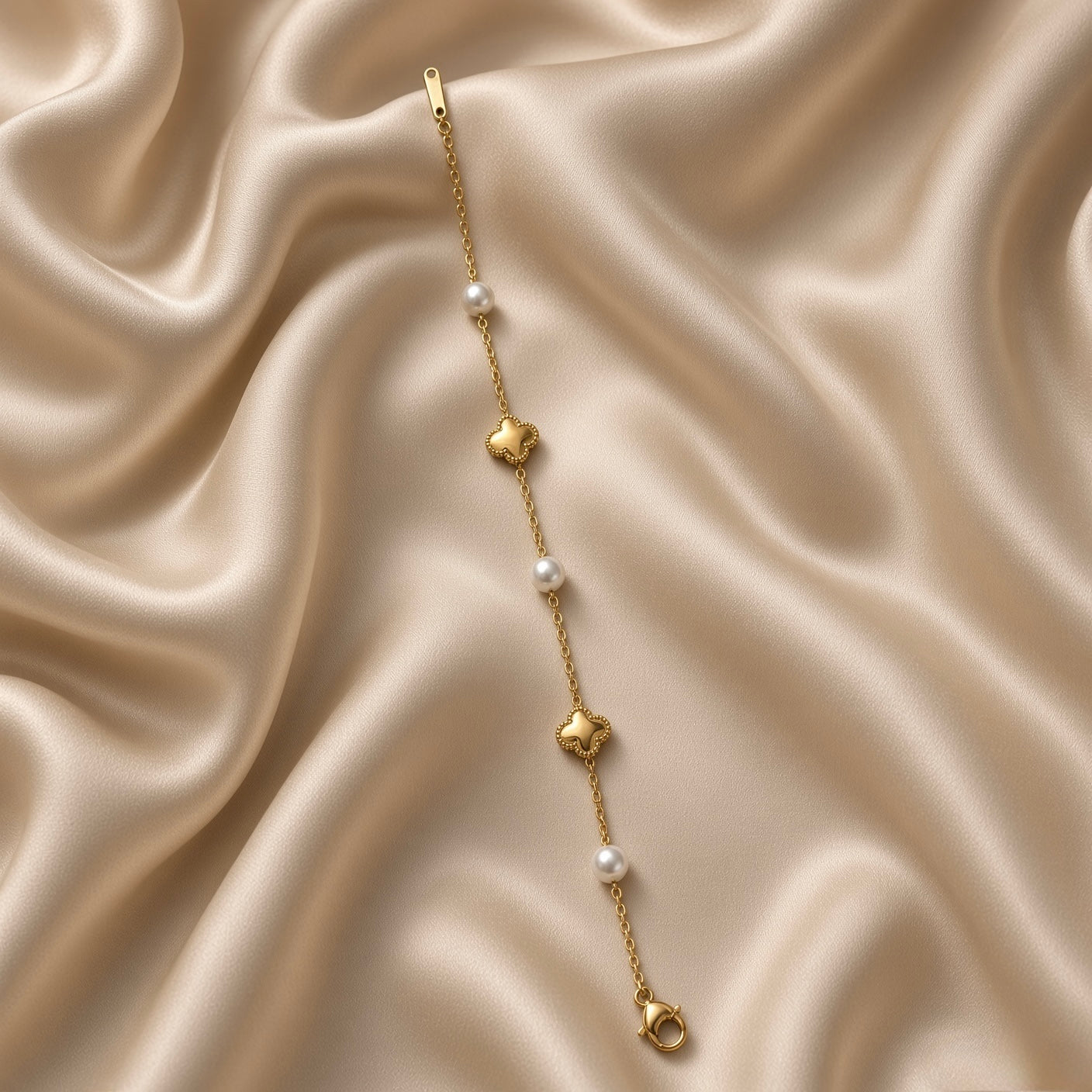 Gold Star and Pearl Station Bracelet Milgrain - circular flat lay on cream satin: fine gold cable chain with six alternating stations, three puffy milgrain-border gold five-pointed star charms and three round white freshwater pearl stations, lobster clasp with engraved gold bar tag at bottom