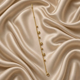 Gold Heart and Ball Charm Bracelet Milgrain Curb Chain - circular flat lay on cream satin showing full bracelet loop: bold gold curb chain with three puffy milgrain gold heart charms and three smooth round gold ball charms alternating, lobster clasp with engraved gold bar tag at bottom centre