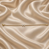 Double Pear Crystal Tennis Bracelet Gold Round Bezel - close vertical flat lay on cream satin: second angle of full tennis chain showing continuous round brilliant crystal bezel stations in warm gold, double pear white crystal zirconia accent at centre, rounded tops touching and pointed tips descending in double teardrop composition