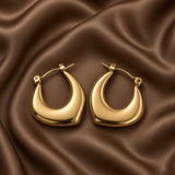 Chunky Crescent Moon Hoop Earrings Gold Mirror Polish - pair close flat lay on dark brown satin: front-facing view of both crescent moon hoops showing rounded outer arch, deep concave inner crescent cut, chunky domed volume, warm mirror-polish 18K gold surface, click-hoop clasps at hoop body