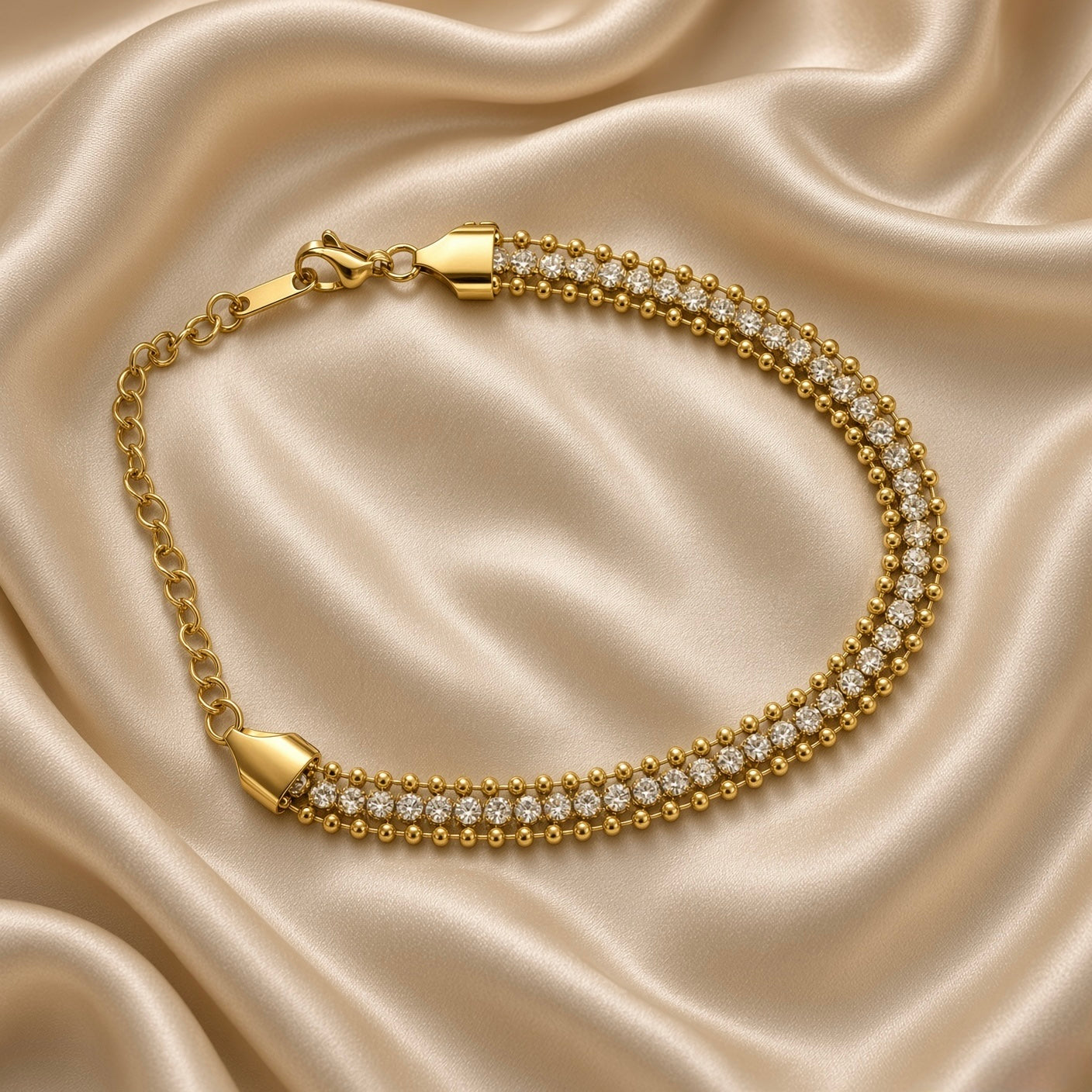 Gold Three Row Bracelet Crystal Tennis Centre Ball Bead Chain Lobster Clasp - overhead circular flat lay on cream satin: full bracelet in circular form showing complete three-row bead-crystal-bead architecture, warm gold tapered shield end caps gathering all three rows, lobster clasp and extension chain at top, cream satin background