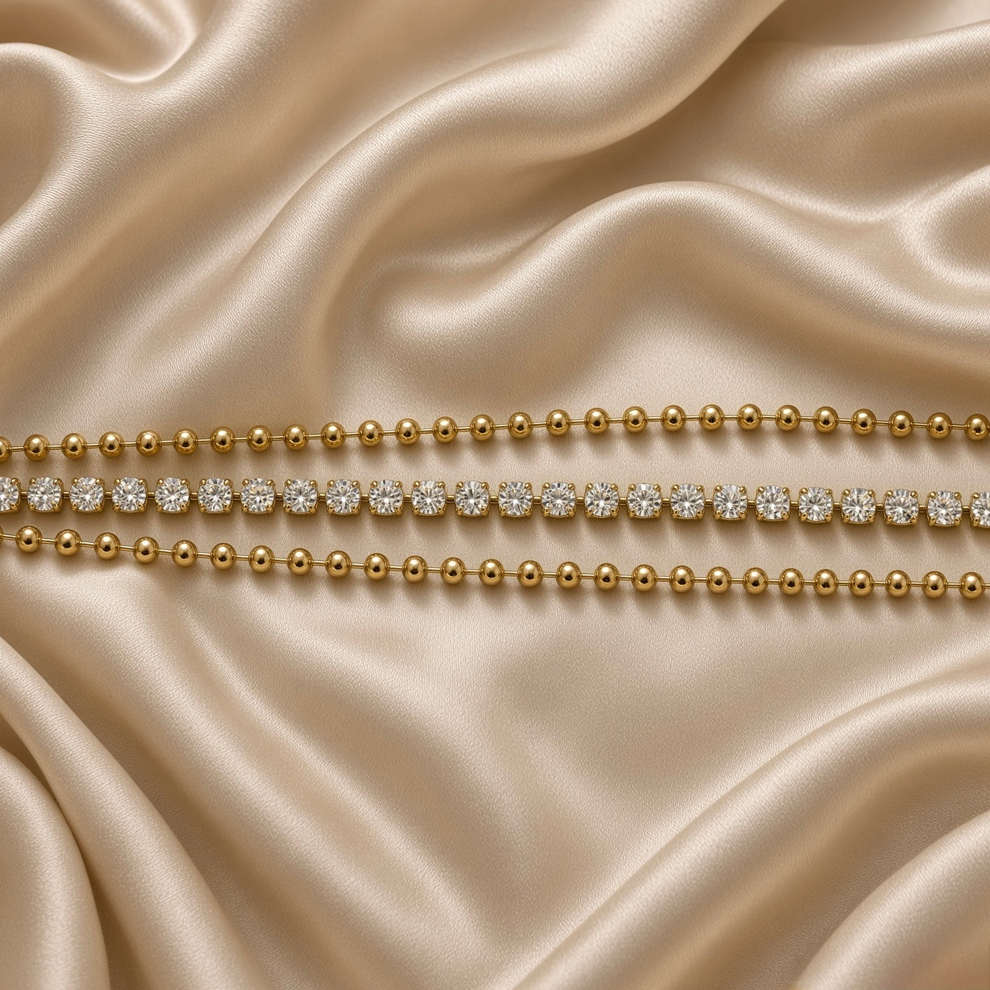 Gold Three Row Bracelet Crystal Tennis Centre Ball Bead Chain Lobster Clasp - macro detail flat lay on cream satin: extreme close-up of three-row architecture showing individual smooth warm gold ball bead spheres in upper and lower rows, individually four-claw cup-set round brilliant white crystal zirconia stones edge-to-edge in centre tennis row, warm 18K gold surface texture of beads and crystal cup settings visible in detail, cream satin background