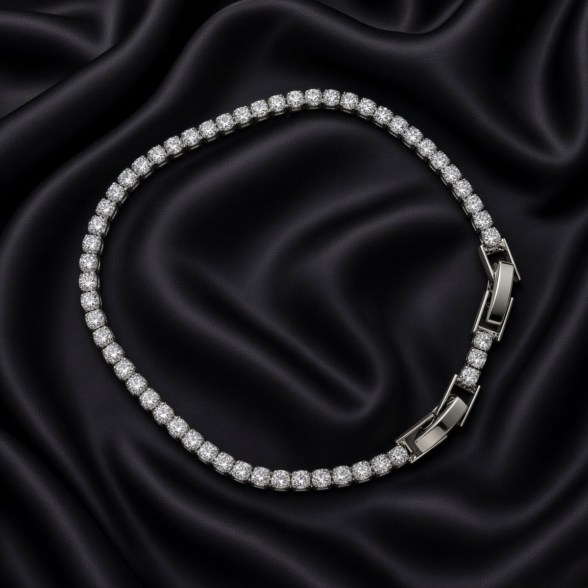 Close-up of silver-tone crystal tennis bracelet with fold-over clasp on black satin
