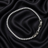 Close-up of silver-tone crystal tennis bracelet with fold-over clasp on black satin