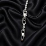 Silver-tone tennis bracelet with clear round crystal-style stones arranged on black satin