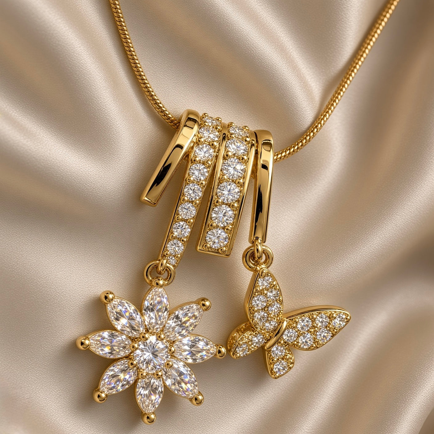 Full view of gold-tone chain necklace with flower and butterfly drop pendant on cream satin