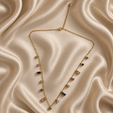 Close-up of gold-tone necklace with green, pink, blue, yellow and clear crystal-style drops